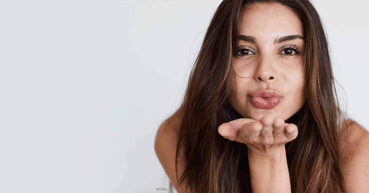 Woman with Juvederm blowing kiss.